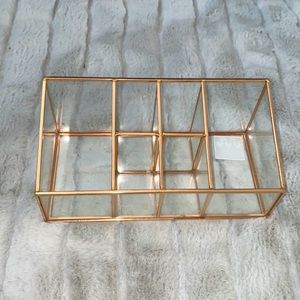 Glass makeup organizer with rose gold detailing